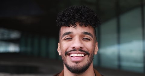 Young latin man smiling on camera outdoor