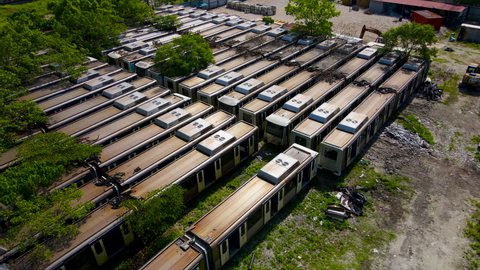 4K aerial footage of Train cemetery, abandoned old LRT locomotives trains lie on the ground.