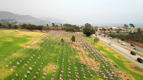 Waves of Flags At Pepperdine University With Traffic Driving Along Pacific Coast Highway In Malibu, California. - aerial