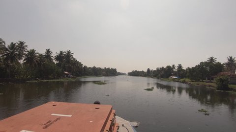 Navigable canal of Alappuzha or Alleppey seen from bow of boat inement, India
