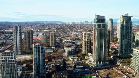 High-rise Buildings In Burnaby With Downtown Vancouver In The Background In Canada. - aerial pullback