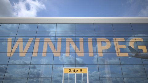 Airliner reflecting in the windows of airport terminal with WINNIPEG text