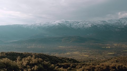 Panning across the Regino valley and Lac de Codole in the Balagne region of Corsica with the snow capped mountains of Monte Padru, Monte San Parteo and Monte Grosso in the distance
