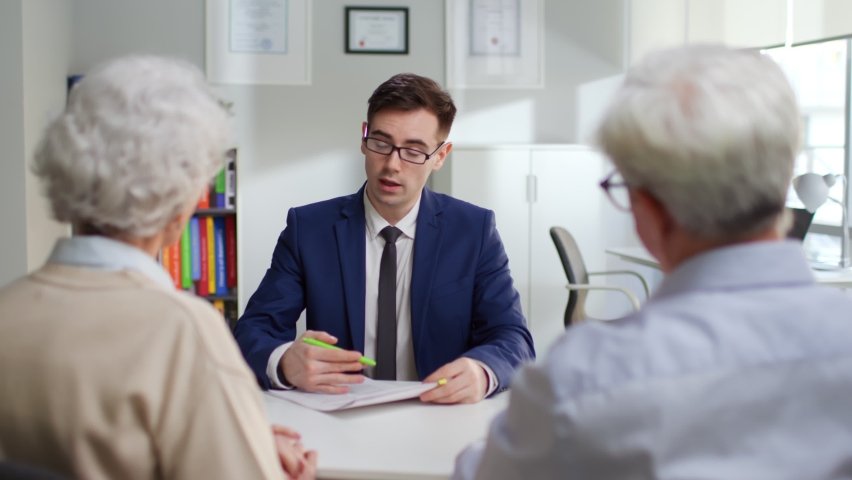 Bank manager explain mortgage details to aged couple in modern bank office. Senior man and woman have meeting with family accountant | Shutterstock HD Video #1089014685
