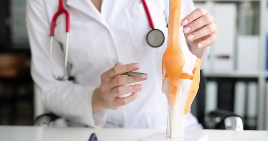 Doctor shows anatomy of structure of human knee joint Royalty-Free Stock Footage #1089014797