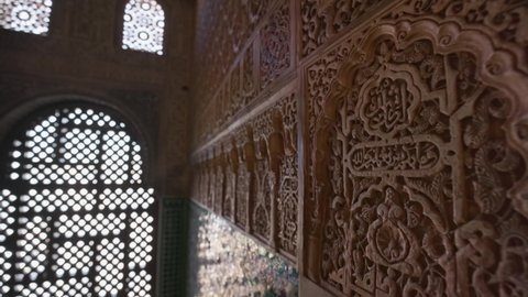 Wall details and Magnificent moorish interior in Alhambra palace, Granada. Camera moves to arches of the window between the walls with Moorish ornaments. Gimbal shot, 4K