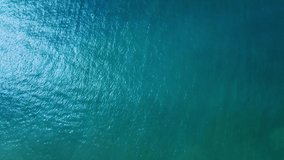 Sea, top view. Reflection of the sun and calm waves. Real top view of the ocean from a drone. Video background