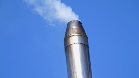 smoke from stainless steel metal pipe. Chimney pipe of a country house. Solid fuel heating, alternative fuel, biofuel. Air pollution