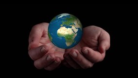 video hands holding world ball on black background. Elements of this image furnished by NASA