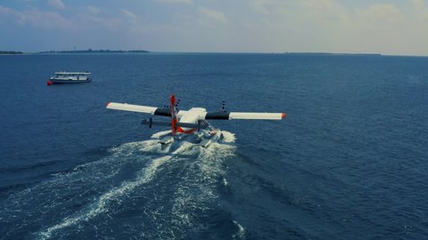 Aerial view on seaplane takes off from blue ocean water in the Maldives