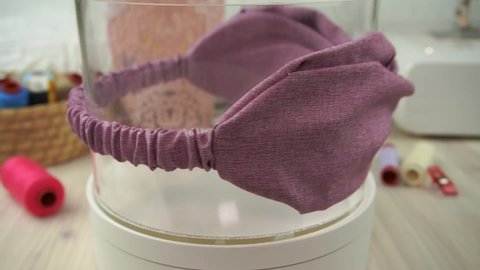 A headband with twisted pattern made out of cotton fabric in dusty purple color, great as hair accessories for babies and kids.