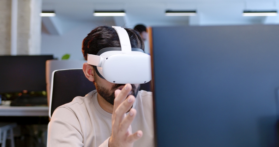 Close up of Arab man in VR glasses moving hands in air. Male in headset having virtual reality experience. Moving hands in air. Futuristic. Augmented. IT team. Call center of future. Coworking space. Royalty-Free Stock Footage #1089022593