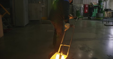 Worker Pulls A Cart With Molten Block Of Metal For Further Forming At Smithery. Smithery At Production Factory. Working Process. Industrial Line. Working In Smithery. At Modern Plant.