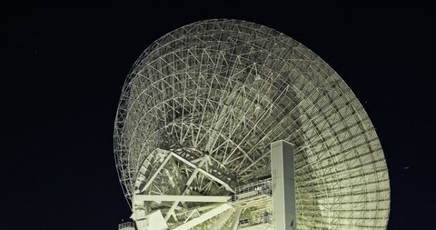 Astronomical radio telescope looking up at the black night sky. Radio telescopes are used in science for space observation and distant objects exploring.