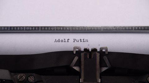 Typing phrase "Adolf Putin" on retro typewriter.