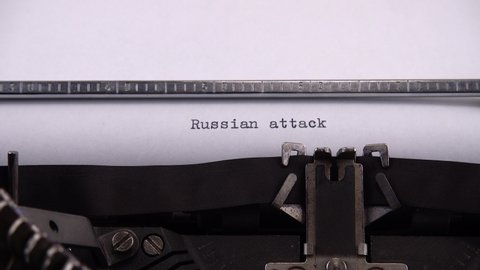 Typing phrase "Russian attack" on retro typewriter.