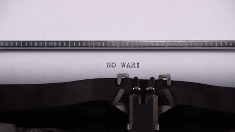 Typing phrase "NO WAR !" on retro typewriter.