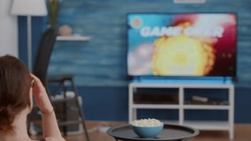 Closeup of gamer girl holding wireless gamepad disappointed because losing online first person shooter game in front of big screen tv. Woman on couch unhappy with performance in gaming simulation. - Powered by Shutterstock - Get 15% off with code: PIKWIZARD15