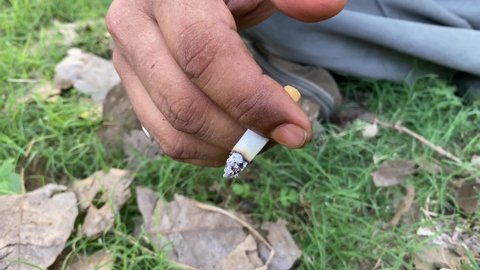 Close up shot of a man smoking a cigarette outdoor close-up. smoke fire light. man's lips. addiction tobacco smoker poison. Shot in 4k.