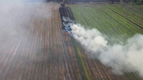 Steady aerial footage then moves over the burning grass in Pak Pli, Nakhon Nayok, Thailand.