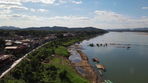 Reverse aerial footage revealing the Laos Thailand border at the Mekong River, Walking Street in Chiang Khan, Loei in Thailand.