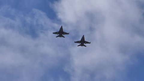Gran Canaria Spain OCTOBER, 21, 2021 Pair of fighter jet planes in flight in formation in the blue sky seen from below. McDonnell Douglas F-18 Hornet of Spanish Air Force