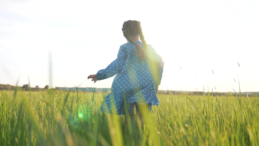 Girl run in field on green grass. Happy child plays and dream. Girl in flower garden.Happy child run towards dream on green grass. Girl playing on flower field in garden.Children fun and joy in summer Royalty-Free Stock Footage #1089033847