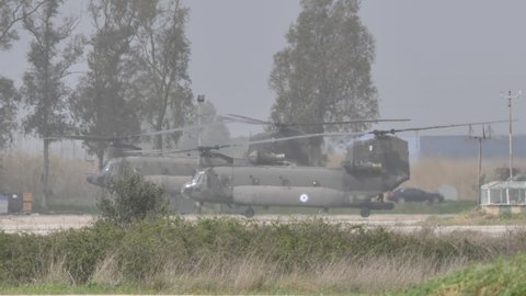 Andravida Greece APRIL, 1, 2022 Two grey tandem rotor chopper landing on NATO helipad after a combat mission. All weather helicopter. Boeing CH-47 Chinook of Hellenic Army