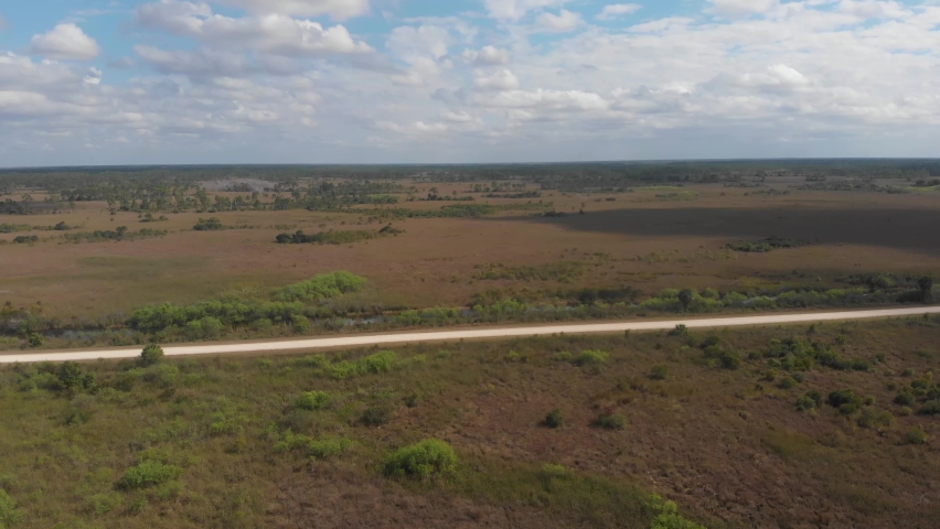 cloudsing across wetland swamp grass horizon vast road everglades florida aerial drone