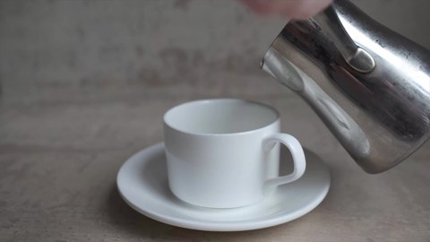  Coffee is carelessly poured into a cezve cup and spilled past. High quality FullHD footage