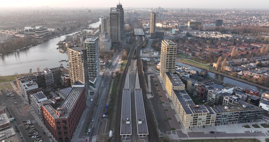 Amsterdamn Amstel urban city aerial drone view transportation and urban residential construction towers. Infrastructure train station business buildings and skyline. Water canal.