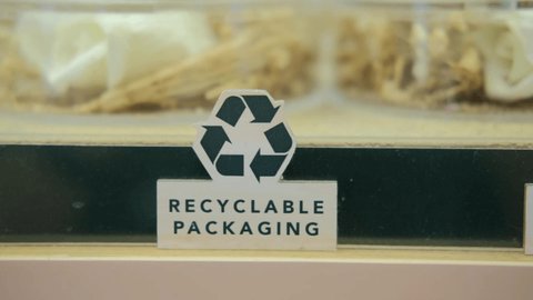 A sign of recyclable packaging, a symbol of nature conservation and reduction of garbage in the form of packaging on the planet. An ethical goods store uses recyclable packaging for its products.