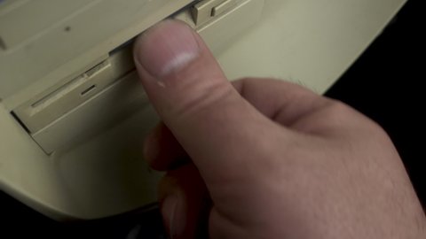 Floppy Disk With Top Secret Documents, Hand Inserting Diskette Into PC Drive. Close Up