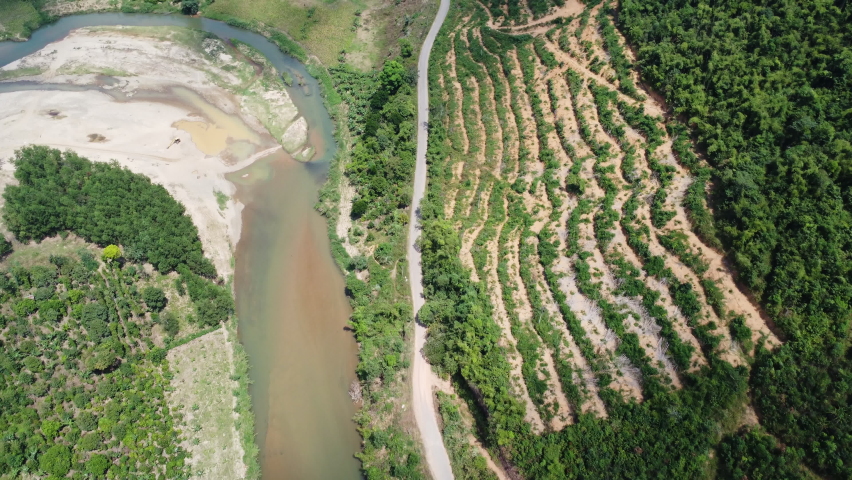 Aerial forward view over slope deforested next to river. Cam Ranh. Vietnam Royalty-Free Stock Footage #1089046929