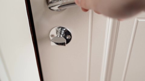 The hand closes the door and locks it. And checks if the door is closed. Closing the door from the inside. High quality 4k footage