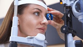 Beautiful woman at ophthalmologist's examination. Doctor's hand holds a tool close to the patient's eye. Close up. - Powered by Shutterstock - Get 15% off with code: PIKWIZARD15