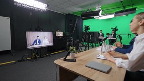 Multicam live broadcast, news anchors at work, view of a backstage studio TV news shooting, interview recording, chroma key template.