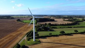Aerial drone footage (circling) of wind turbine in rural landscape in the scenic morning light in Northern Germany
