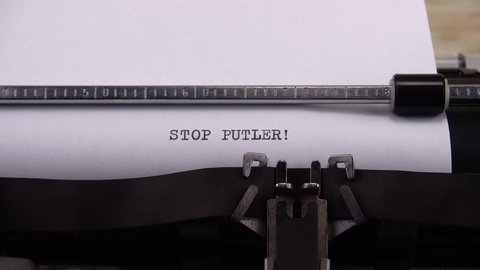 Typing phrase "STOP PUTLER !" on retro typewriter.