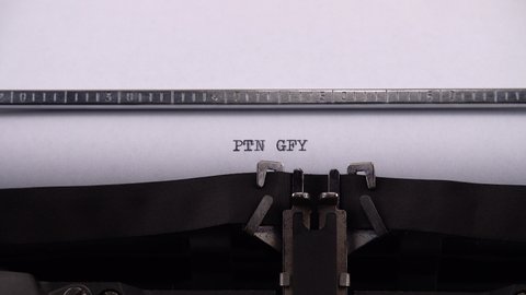 Typing phrase "PTN GFY" on retro typewriter.