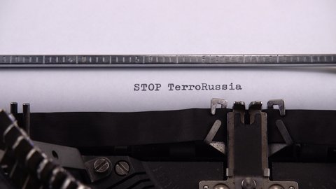 Typing phrase "STOP TerroRussia" on retro typewriter.