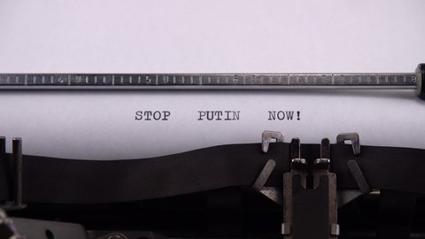 Typing phrase "STOP PUTIN NOW !" on retro typewriter.
