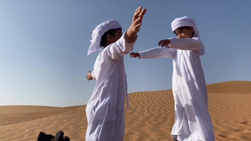 Happy cute smiling Emirati kids hugging . Arab children wear traditional Arabic dress in desert Royalty-Free Stock Footage #1089057679