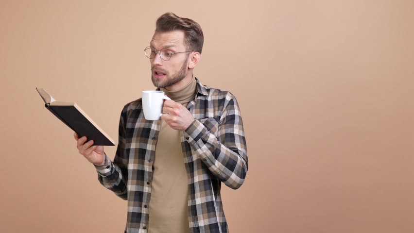 Smart guy hipster read textbook drink mug isolated pastel color background | Shutterstock HD Video #1089059013