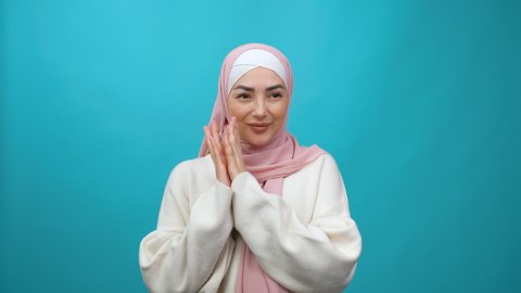 Cunning Young Muslim woman in hijab thinking devious tricks cheats, twiddle fingers smirking and scheming evil plan, trying to plot something sly in mind. Isolated studio shot