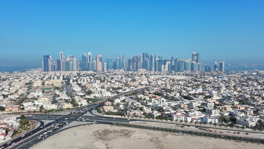 Doha, Qatar: Aerial view of capital city of Qatar, cityscape with skyscrapers skyline of West Bay site on horizon - landscape panorama of Arabian Peninsula from above, West Asia Royalty-Free Stock Footage #1089059633