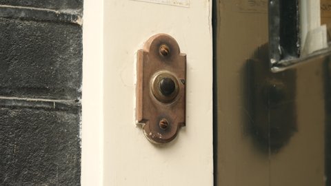 Ringing a frontdoor doorbell. Close up. 