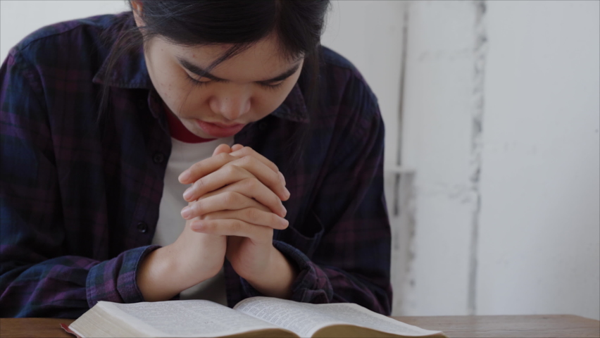 woman asian holding hands pray to god blessing with the bible for wishing have a better life on a wooden table. Christian life crisis prayer concept Royalty-Free Stock Footage #1089063431