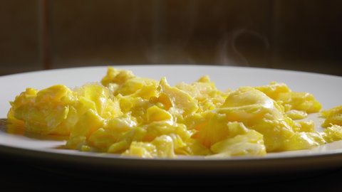 Smoking Hot Scrambled Eggs On a White Plate - Steady Shot