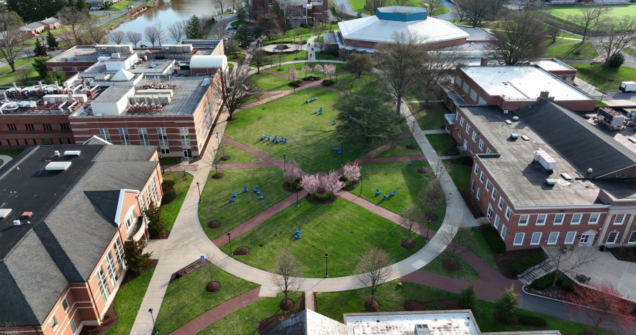 University college campus during spring scene. Green space among academic buildings, church chapel and blooming trees.